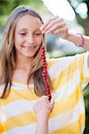 Jeune fille souriante tenant des fraises des bois sur la chaîne