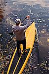 Man rowing paddle board in water, elevated view