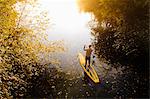 Man rowing paddle board in water, elevated view