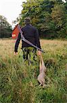 Hunter dragging deer through field