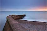 Jetée de pierre sur Sidmouth sur la plage au coucher du soleil, Sidmouth, Devon, Angleterre, Royaume-Uni, Europe