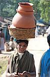 Dunguria Kondh woman with tribal noserings carrying terracotta pots in a basket on her head, Bissam Cuttack, Orissa, India, Asia