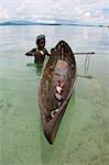 Young boy goes fishing with his canoe and harpoon, Marovo lagoon, Solomon Islands, Pacific