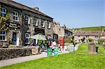 Personnes assises devant un magasin de thé sur le Green Village à Burnsall, Wharfedale, Yorkshire Dales, Yorkshire, Angleterre, Royaume-Uni, Europe