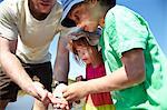 Father and children examining objects