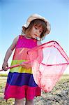 Girl examining fishing net outdoors