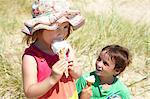 Enfants manger des glaces sur la plage