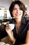 Smiling woman having coffee in cafe