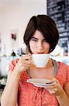 Smiling woman drinking coffee in cafe