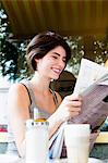 Woman reading newspaper in cafe