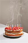 Bougies de fumer sur le gâteau d'anniversaire