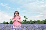 Jeune fille debout dans le champ de fleurs