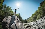 Woman with arms outstretched on rock