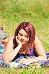 Woman reading book in grass