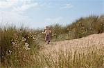 Boy running in grassy sand