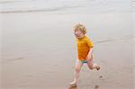 Boy running in waves on beach