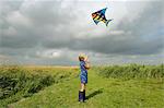 Fille flying kite dans domaine rural