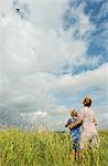 Mother and daughter flying kite in field