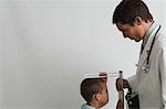 Messung von kleinen Jungen während Check-up-Arzt