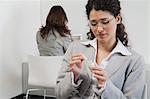 Woman painting her fingernails at work