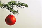 Red Christmas bauble hanging from Christmas tree