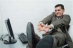 Businessman stretching at desk in office