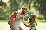 Young women playing, one woman giving another piggyback ride