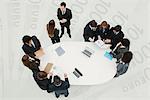 Business associates in meeting, standing on superimposed image of one-hundred Euro banknotes