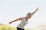 Mature woman exercising with arms outstretched