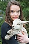 Teenage girl holding lamb