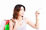 happy young woman with shopping bag pointing at something