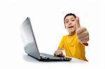 young boy in yellow t-shirt with laptop showing thumbs up at camera isolated on white background