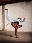 Strong African man demonstrating a Capoeria one armed kick