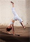 Young woman performing a cartwheel on floor