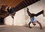 Two acrobatic capoeria artists do headstands and backflips