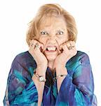 Furious elderly woman with hands on face