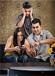 Embarrassed Hispanic teenager behind parents playing video games