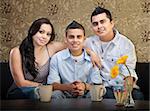 Smiling young Latino family of three sitting together