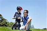 happy smiling father with his son on a balance bike