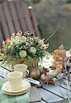 Autumn fruits, flowers and cup on a table