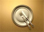 Knife and fork on a golden plate