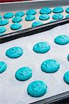 Tas de pâte de macaron bleu sur papier sulfurisé