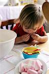 Jeune fille mangeant des bonbons lors de la cuisson