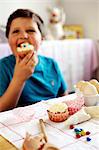 Young boy eating a cupcake