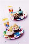 Bunte Muffins und Orangensaft für die Geburtstagsfeier eines Kindes