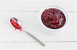 Stewed lingonberries in a bowl with a spoon