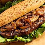 Grilled Steak and Onion Sandwich with Lettuce on a Roll