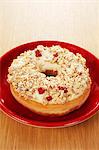 A doughnut topped with oats and cranberries