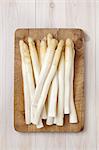 Peeled white asparagus on a chopping board