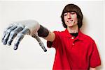 Young man looking at his prosthetic hand over gray background
